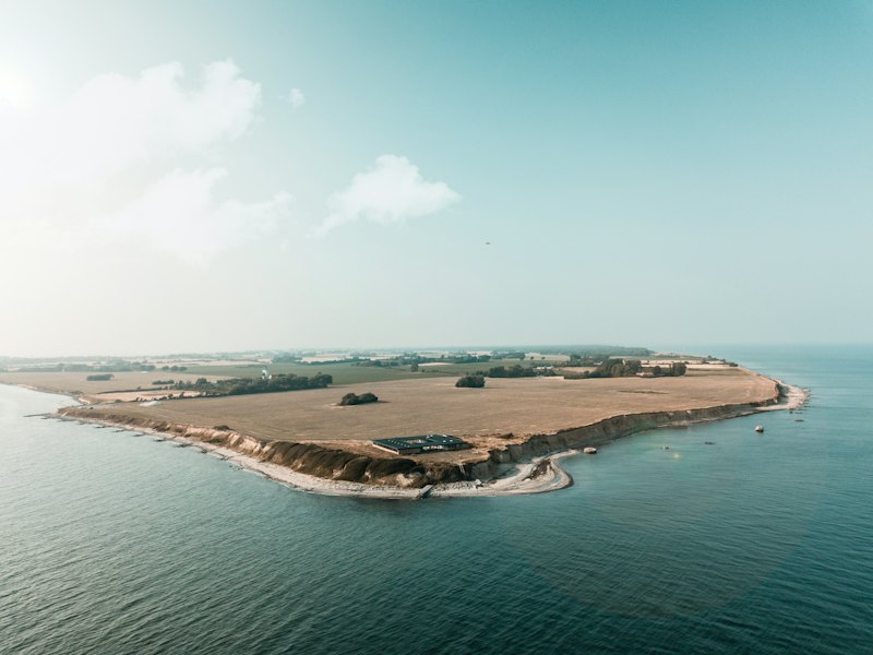 Low green cliffs and a stony shore at Gedser Odde on Falster, Denmark